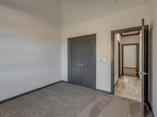 unfurnished bedroom with light carpet and a closet