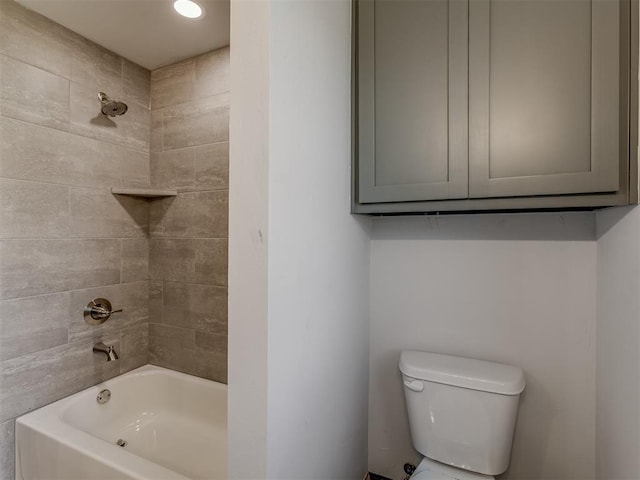 bathroom featuring tiled shower / bath combo and toilet