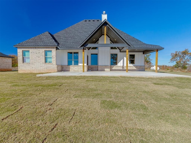 rear view of house with a patio area and a lawn