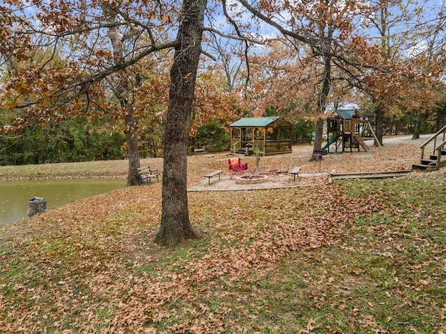 view of yard with a playground and a water view