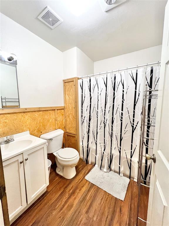 bathroom with hardwood / wood-style floors, vanity, and toilet