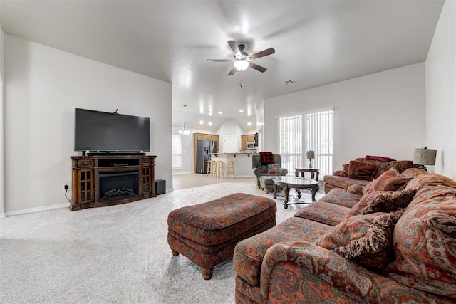 carpeted living room with ceiling fan