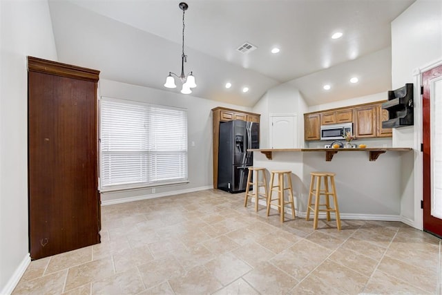 kitchen featuring hanging light fixtures, refrigerator with ice dispenser, kitchen peninsula, lofted ceiling, and a breakfast bar