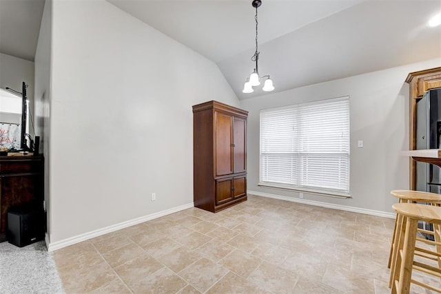 dining space with a chandelier and vaulted ceiling