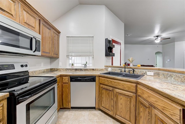 kitchen featuring lofted ceiling, sink, ceiling fan, light tile patterned floors, and appliances with stainless steel finishes