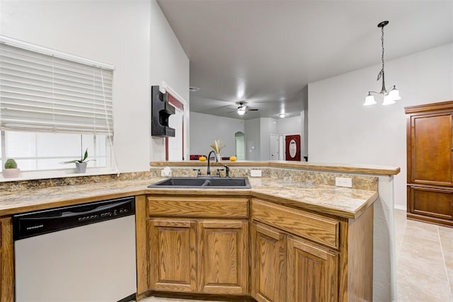 kitchen with sink, kitchen peninsula, white dishwasher, decorative light fixtures, and ceiling fan with notable chandelier