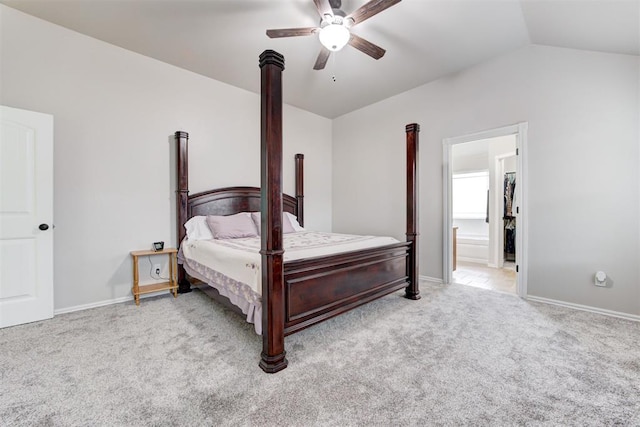 carpeted bedroom featuring ceiling fan, lofted ceiling, and ensuite bathroom