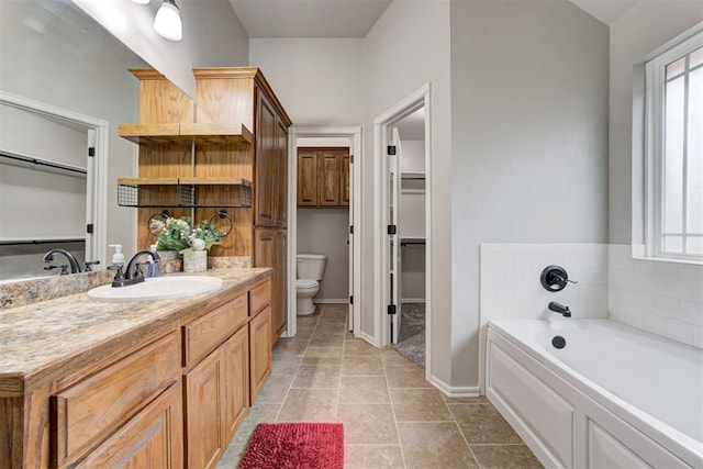 bathroom featuring tile patterned flooring, vanity, a bathtub, and toilet