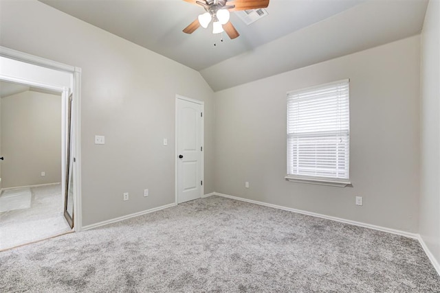 carpeted spare room with ceiling fan and lofted ceiling