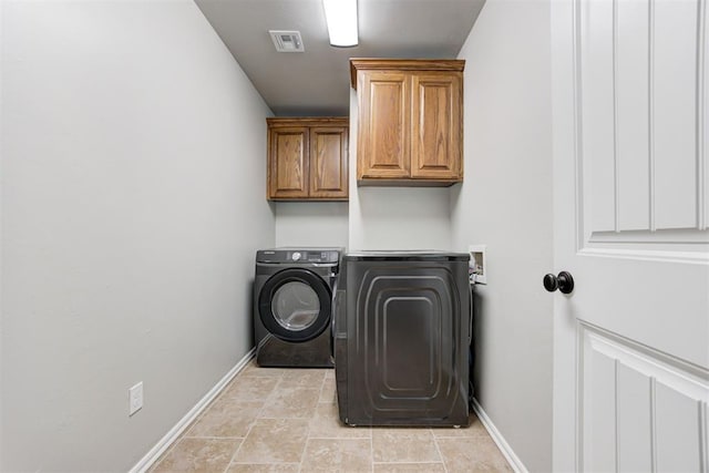 laundry room featuring cabinets and washer / dryer