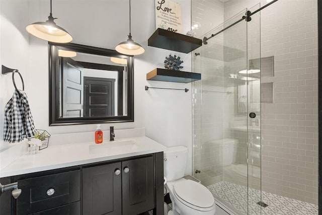 bathroom featuring vanity, an enclosed shower, and toilet