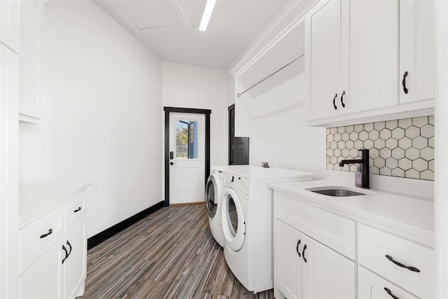 laundry area with cabinets, separate washer and dryer, dark wood-type flooring, and sink