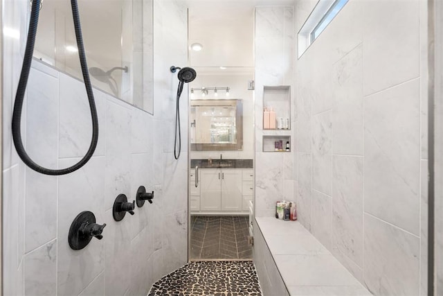 bathroom featuring a tile shower and vanity