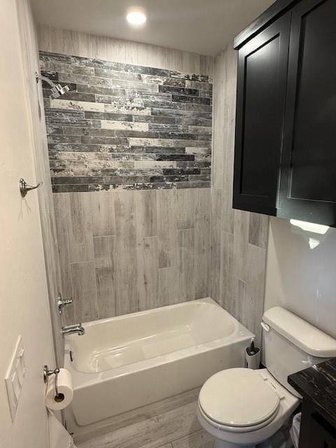 full bathroom featuring toilet, vanity, wood-type flooring, and tiled shower / bath