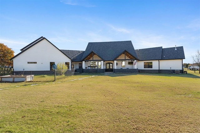 rear view of property featuring a yard and central air condition unit