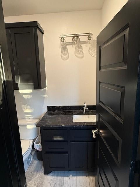 bathroom featuring hardwood / wood-style floors, vanity, and toilet