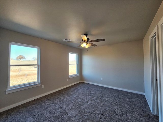 unfurnished room with dark carpet and ceiling fan