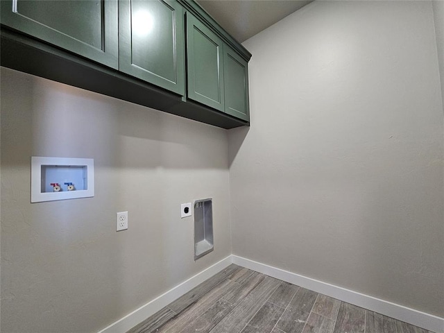 clothes washing area with electric dryer hookup, light hardwood / wood-style floors, cabinets, and washer hookup