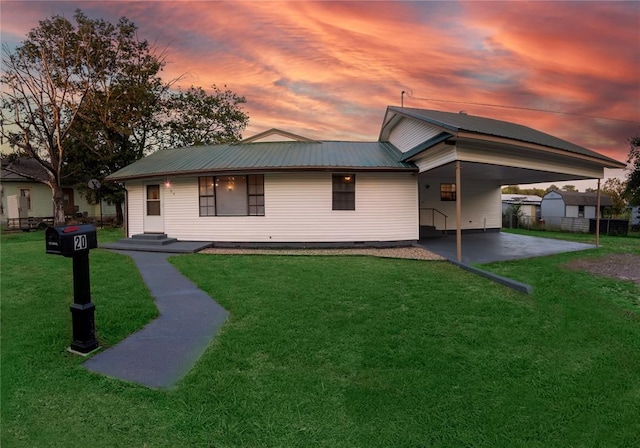 view of front of property featuring a lawn and a carport