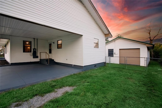 property exterior at dusk featuring a lawn and a carport