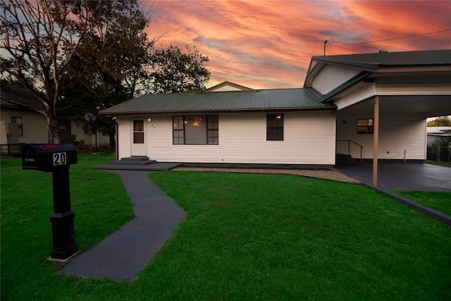 view of front of property with a carport and a yard