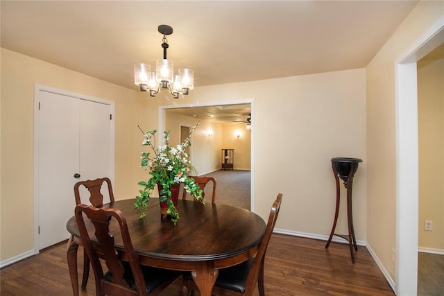 dining area featuring ceiling fan with notable chandelier and dark wood-type flooring