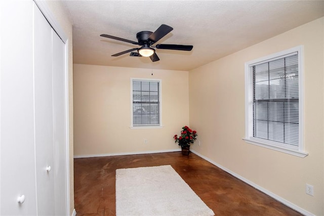 unfurnished room featuring ceiling fan and a textured ceiling