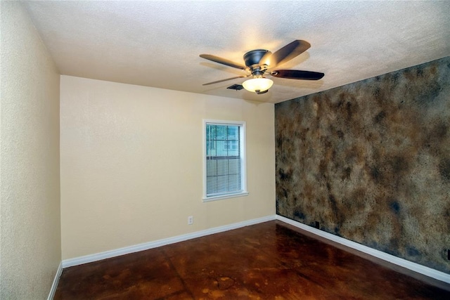 empty room with ceiling fan and a textured ceiling