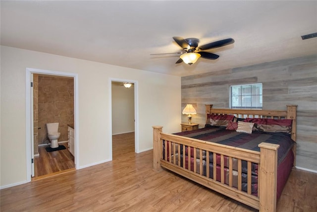 bedroom featuring hardwood / wood-style flooring, ceiling fan, and ensuite bathroom