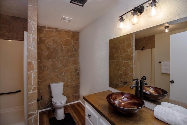 bathroom with a shower, wood-type flooring, vanity, and toilet