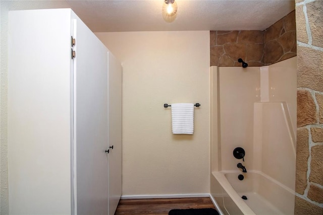 bathroom featuring a textured ceiling, hardwood / wood-style floors, and  shower combination