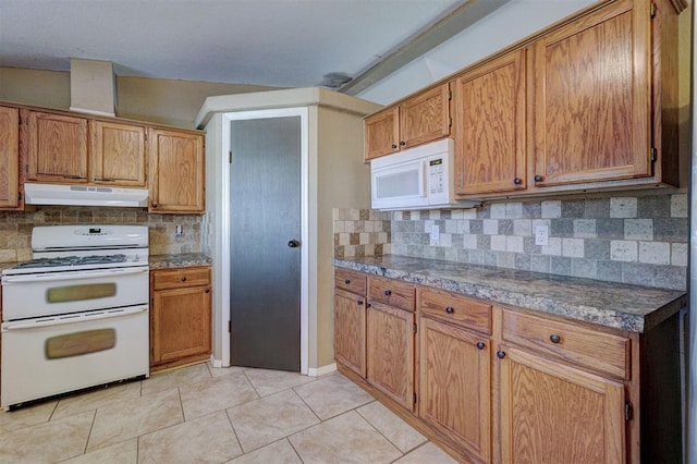 kitchen featuring tasteful backsplash, light tile patterned floors, and white appliances