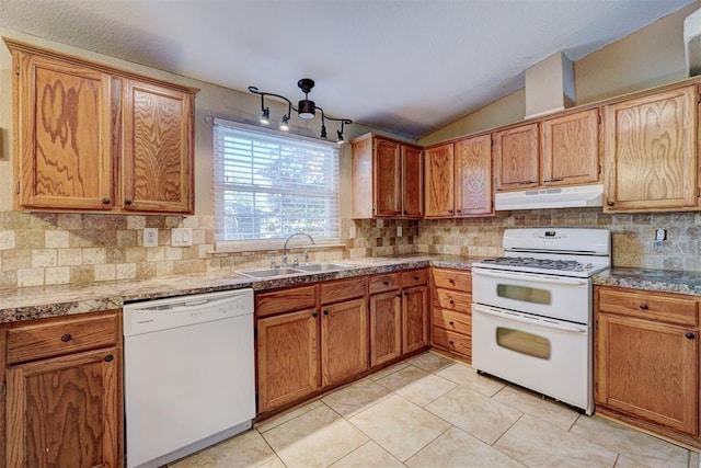 kitchen with white appliances, lofted ceiling, sink, decorative backsplash, and light tile patterned floors