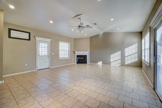 unfurnished living room with ceiling fan, light tile patterned floors, and vaulted ceiling