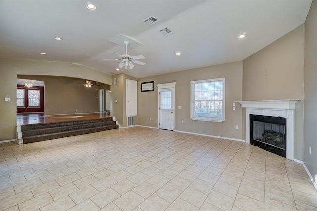 unfurnished living room featuring light tile patterned floors, vaulted ceiling, ceiling fan, and a healthy amount of sunlight