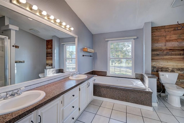 bathroom with tile patterned floors, tiled bath, vaulted ceiling, and toilet