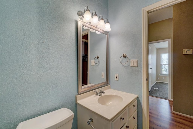 bathroom featuring vanity, hardwood / wood-style flooring, and toilet