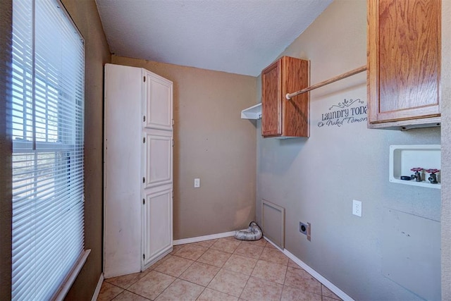 laundry area with cabinets, electric dryer hookup, hookup for a washing machine, a textured ceiling, and light tile patterned flooring