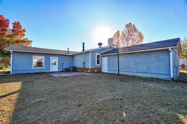 rear view of house with a lawn, central AC, and a patio area