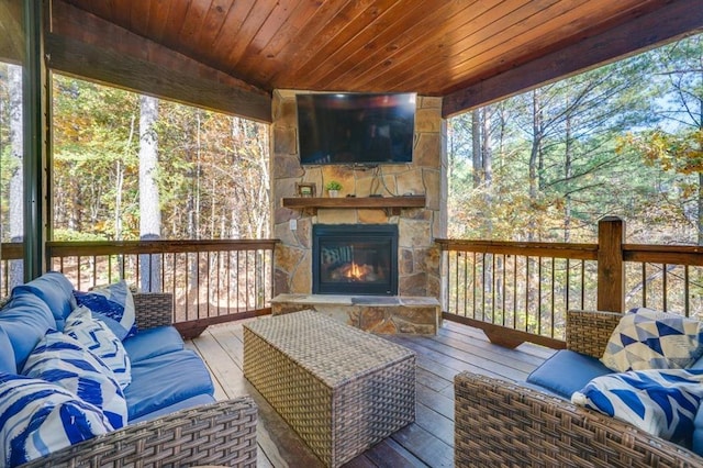 sunroom / solarium with an outdoor stone fireplace and wooden ceiling