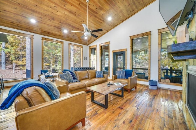 living room featuring ceiling fan, light hardwood / wood-style flooring, high vaulted ceiling, a fireplace, and wood ceiling