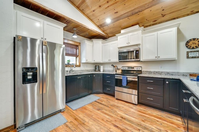 kitchen featuring lofted ceiling, white cabinets, sink, appliances with stainless steel finishes, and light hardwood / wood-style floors