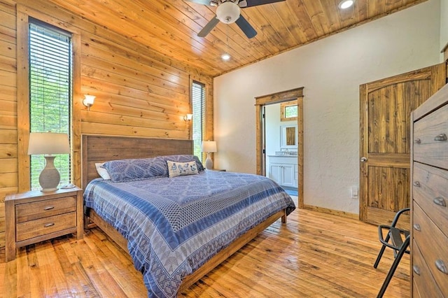 bedroom featuring ensuite bathroom, light hardwood / wood-style floors, wood ceiling, and multiple windows