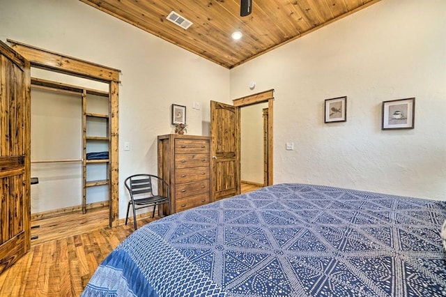 bedroom featuring hardwood / wood-style floors, a closet, wood ceiling, and vaulted ceiling