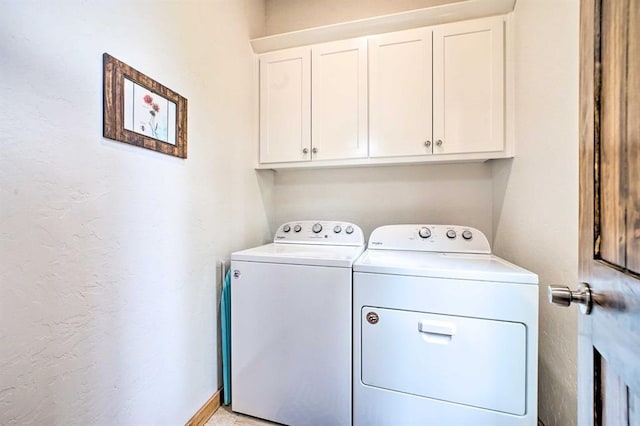 laundry area with washer and dryer and cabinets