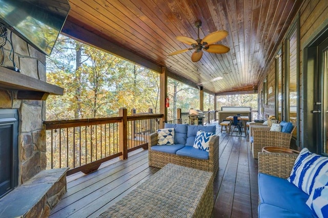 wooden terrace with area for grilling and an outdoor living space