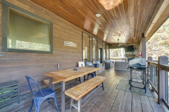 wooden terrace featuring grilling area and ceiling fan