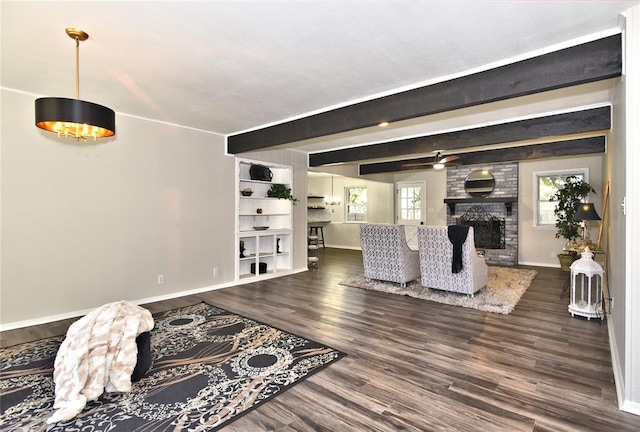 living room featuring beamed ceiling, ceiling fan, a large fireplace, and dark wood-type flooring