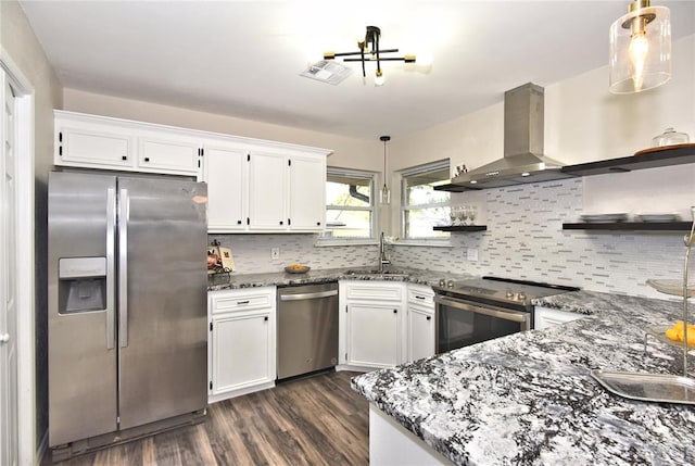 kitchen with white cabinetry, sink, wall chimney exhaust hood, hanging light fixtures, and appliances with stainless steel finishes