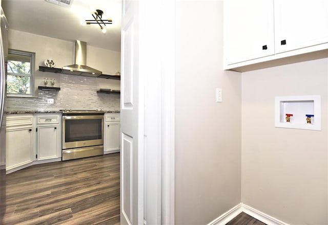 kitchen featuring tasteful backsplash, dark wood-type flooring, wall chimney range hood, white cabinets, and stainless steel electric range oven